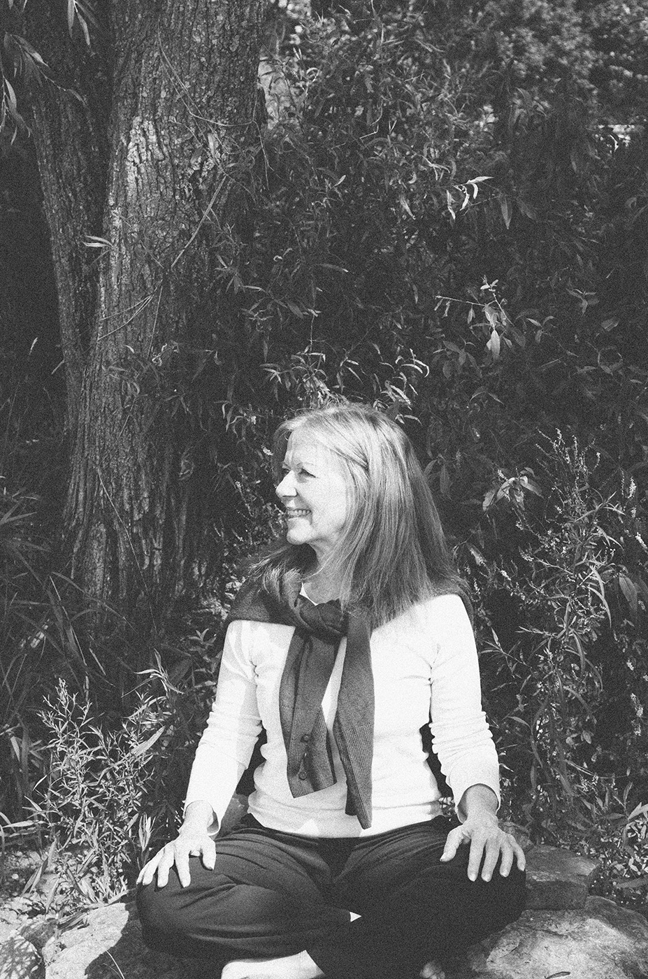 Liz Stokvis seated outdoors in a wooded setting